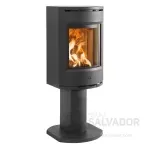 Vista frontal de la estufa Jøtul F 136 con fuego encendido y cristal limpio que enmarca las llamas.