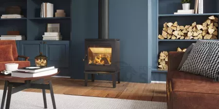 Estufa de leña Jøtul F205 LL encendida, mostrando un diseño escandinavo minimalista y vidrio panorámico.