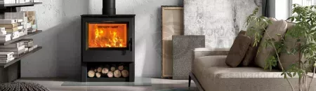 Estufa Hergom EB-1 encendida, mostrando su diseño robusto y su capacidad de generar calor uniforme.