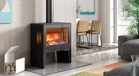 Estufa de leña Hergom Glance LV SE encendida con visión panorámica del fuego.